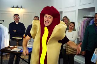 Tim Robinson, wearing a hot dog costume, angrily proclaims, “We're all trying to find the guy who did this.”